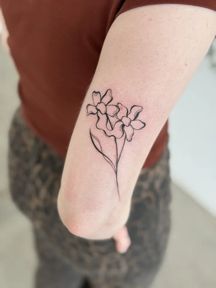 Fine-line blossom bouquet above the elbow